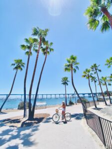 woman-on-a-beach-cruiser-bike-on-vacation-on-coronado island with city captain airport shuttle service